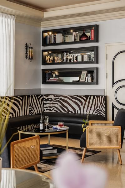 Stylish lounge at Riviera Hotel South Beach with zebra print seating, wicker chairs, and modern wall shelving