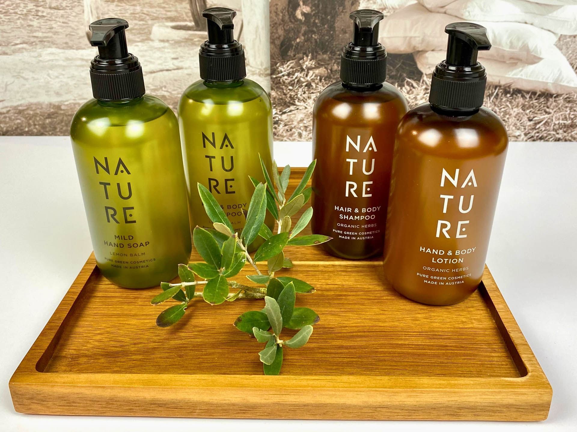 Two eco-friendly Nature cosmetic bottles on a wooden tray at the Avaneo Hotel Marktredwitz