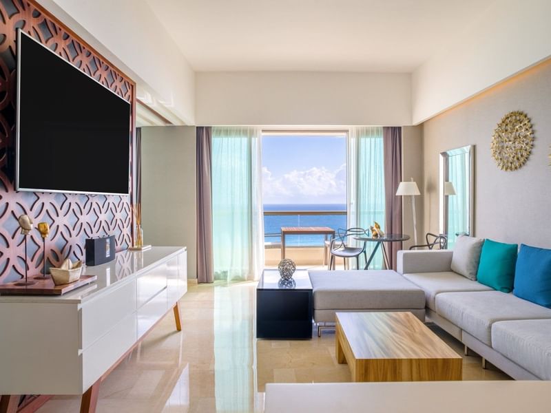 Tierra Suite's living area with TV, cabinet and sea view from the balcony at Live Aqua Beach Resort