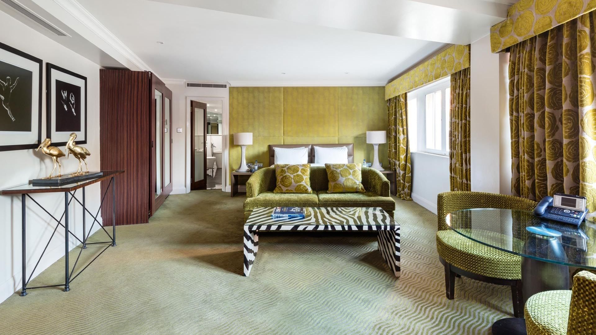Elegant Private Wings room at The May Fair Hotel London with a double bed, zebra-patterned bench, and a round glass table