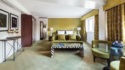 Elegant Private Wings room at The May Fair Hotel London with a double bed, zebra-patterned bench, and a round glass table