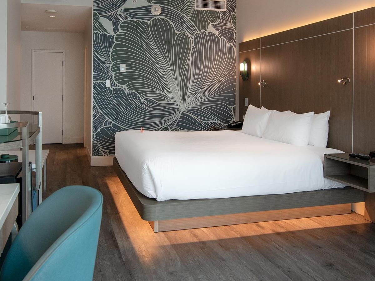 Hotel room with king bed, desk, and modern decor.