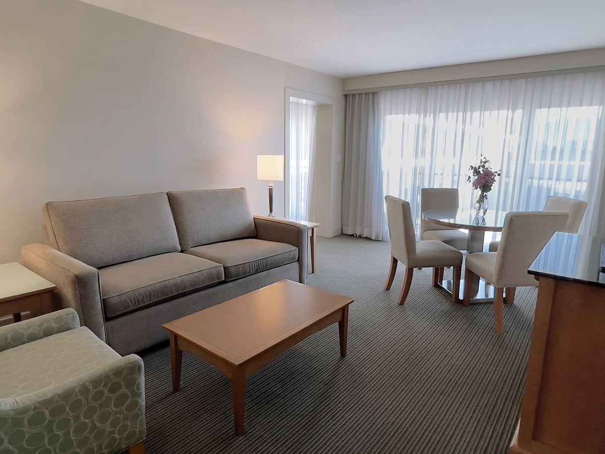 Guest room living area with couch, dining room table, chairs, coffee table