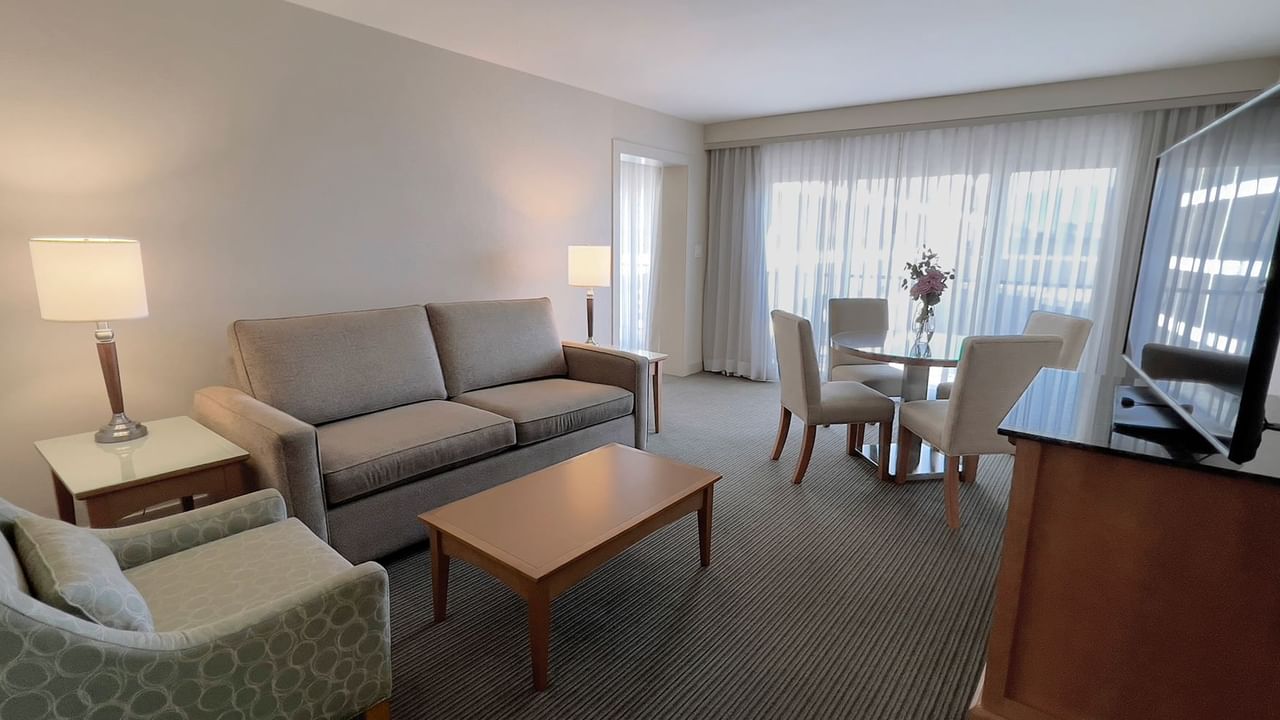 Guest room living area with couch, dining room table, chairs, coffee table