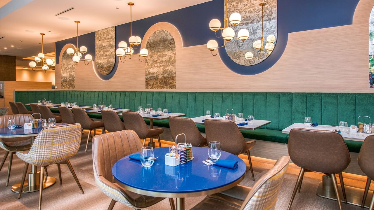 Restaurant with tables, seating, and decorative mirrors.