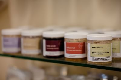 Jars of sugar scrubs on a shelf in August Moon Spa at La Tourelle Hotel and Spa