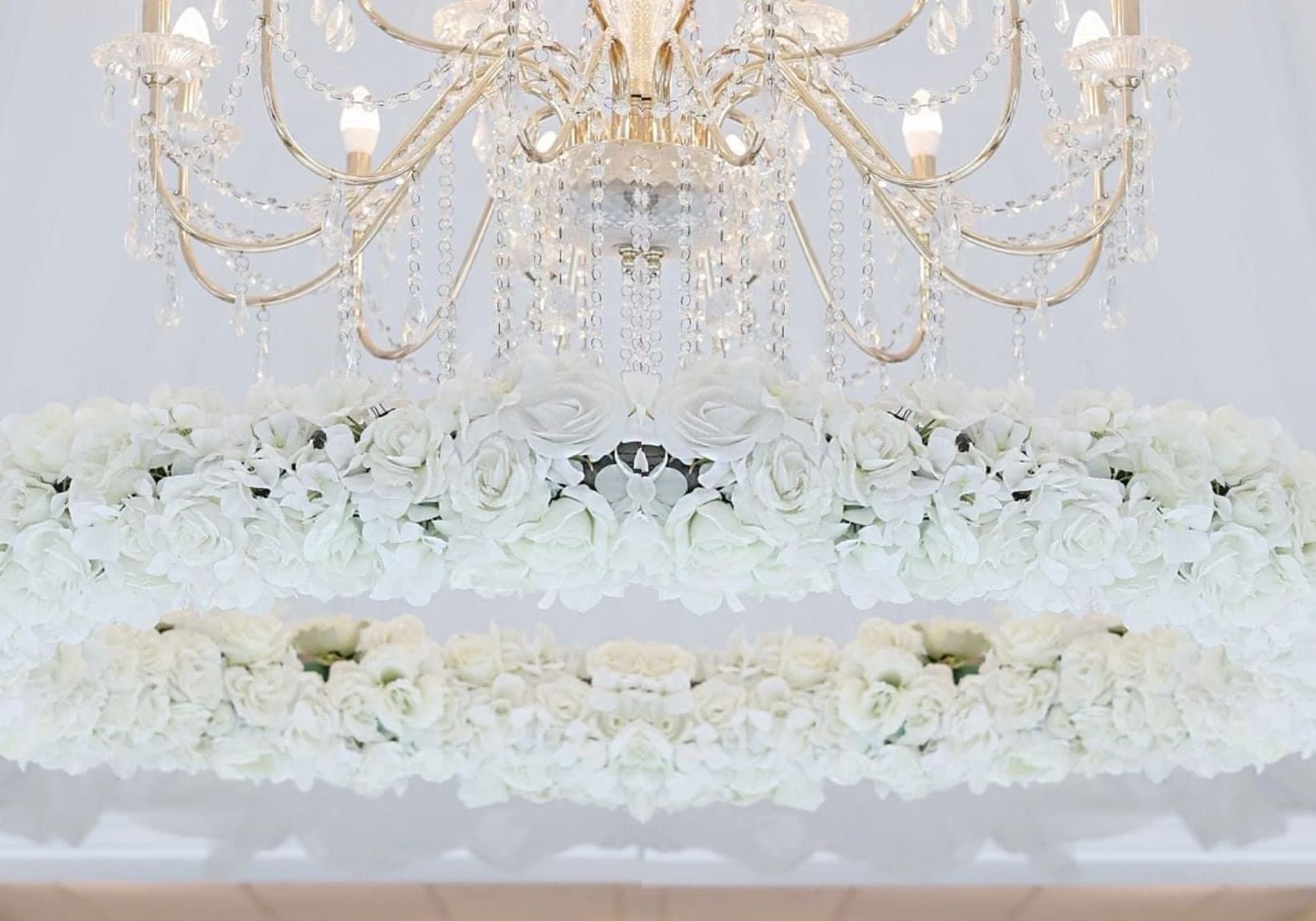 Chairs placed on a stage for the newlyweds & large chandelier at Orsett Hall Hotel