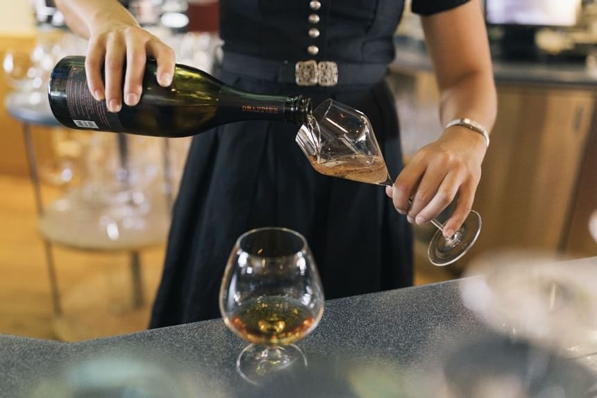 Close-up of a waitress pouring wine into glasses at Liebes Rot