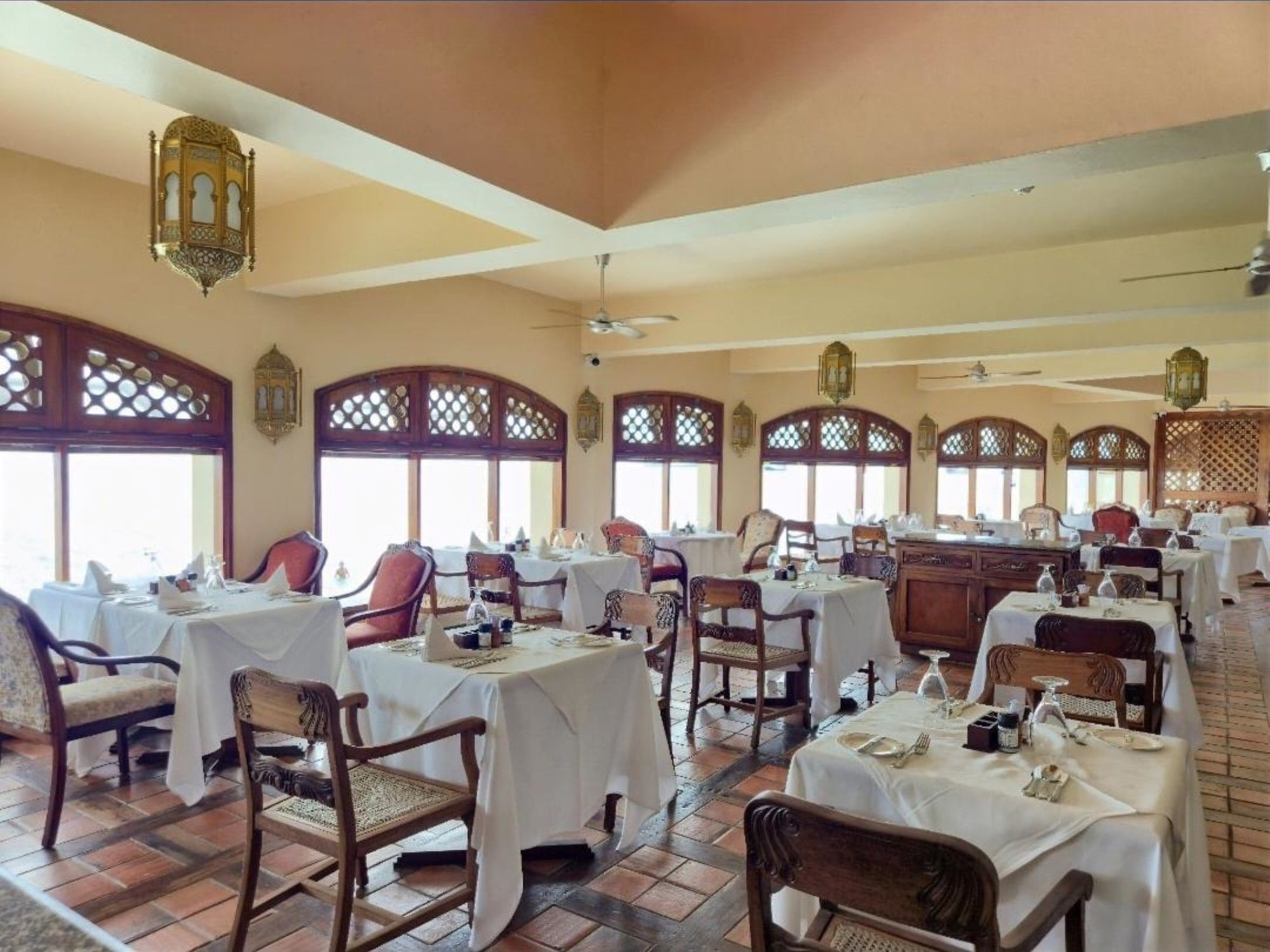 Interior of the elegant Baharia Restaurant with set tables at Zanzibar Serena Hotel in Zanzibar.