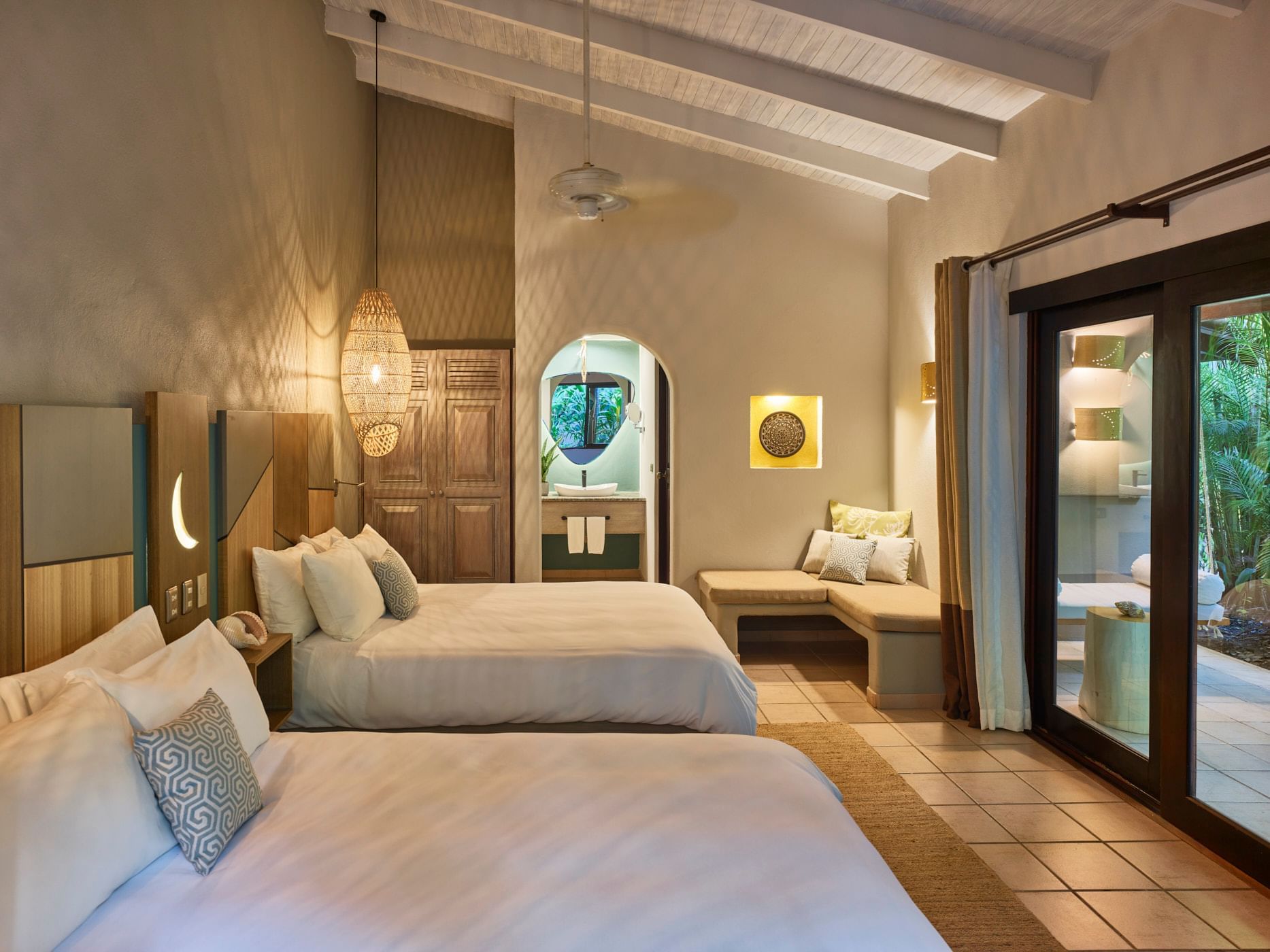 Interior of the Deluxe Room with 2 Queen Beds at Cala Luna Boutique Hotel in Costa Rica.