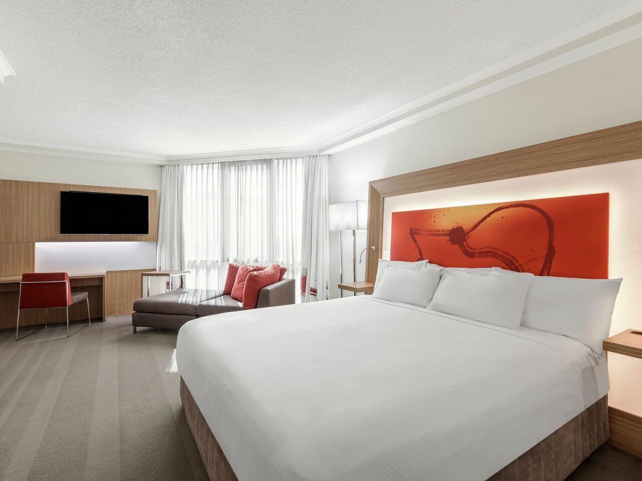 Bed & living area in Standard King Room at Amora Hotel