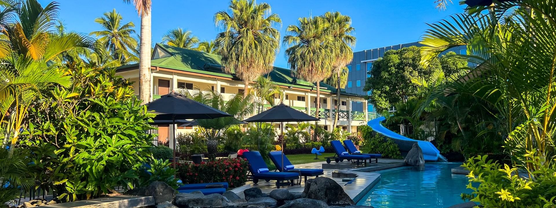Clear pool with lounge chairs and tropical setting at Tokatoka Resort - Fiji International Airport in Nadi