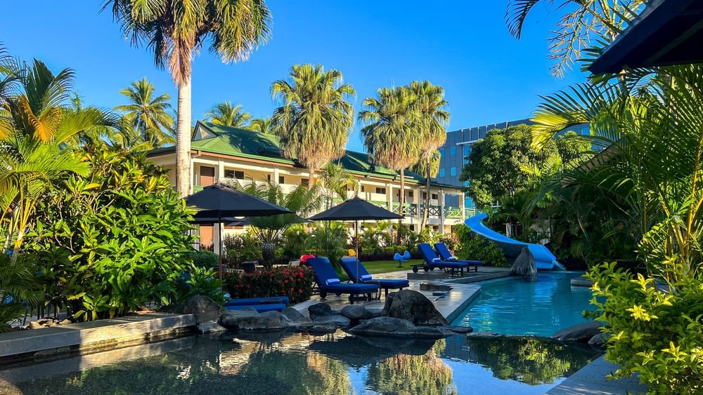 Clear pool with lounge chairs and tropical setting at Tokatoka Resort - Fiji International Airport in Nadi.