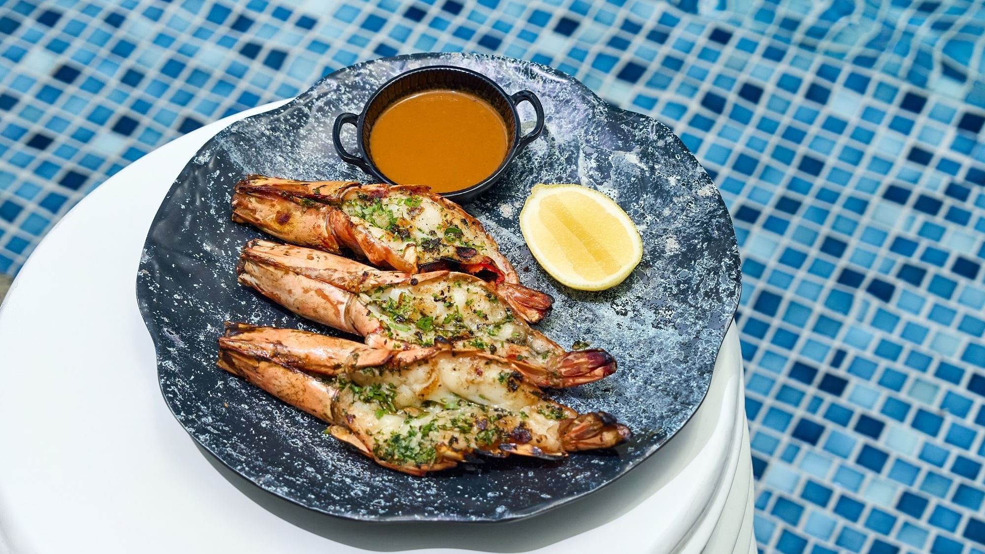Prawns dish served with lemon slice & gravy in Malibu Deck Pool bar at Paramount Hotel Dubai
