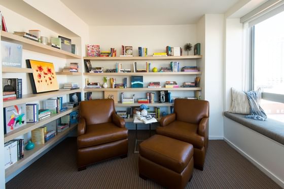 Leather chairs in den with wall book shelves