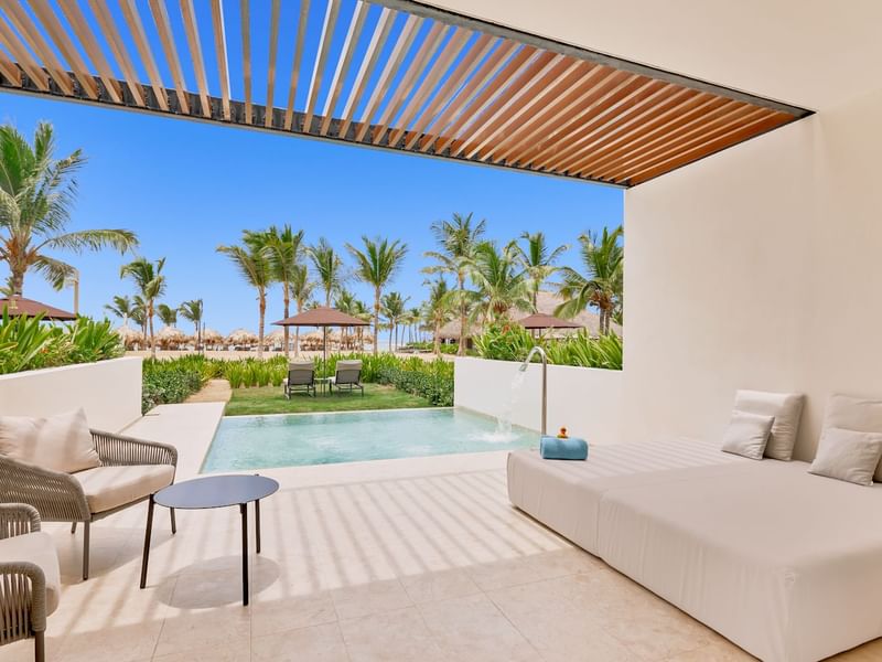 White couches in front of pool with scenic view at Live Aqua Punta Cana