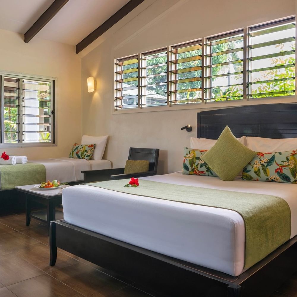 Studio Villa at Tokatoka Resort in Nadi with two beds, tropical decor, and wooden floors.