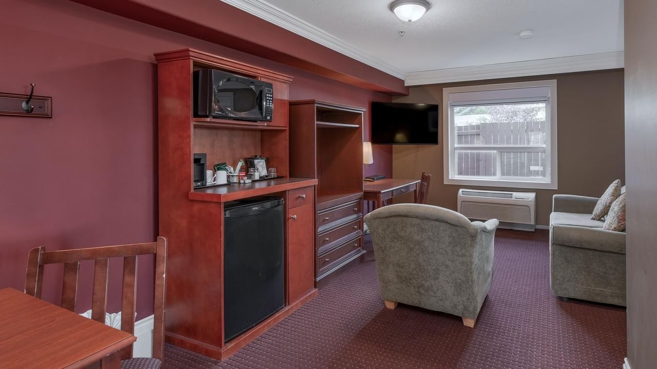 Spacious hotel suite with kitchenette, seating area, and natural light at Coast Edson Hotel.