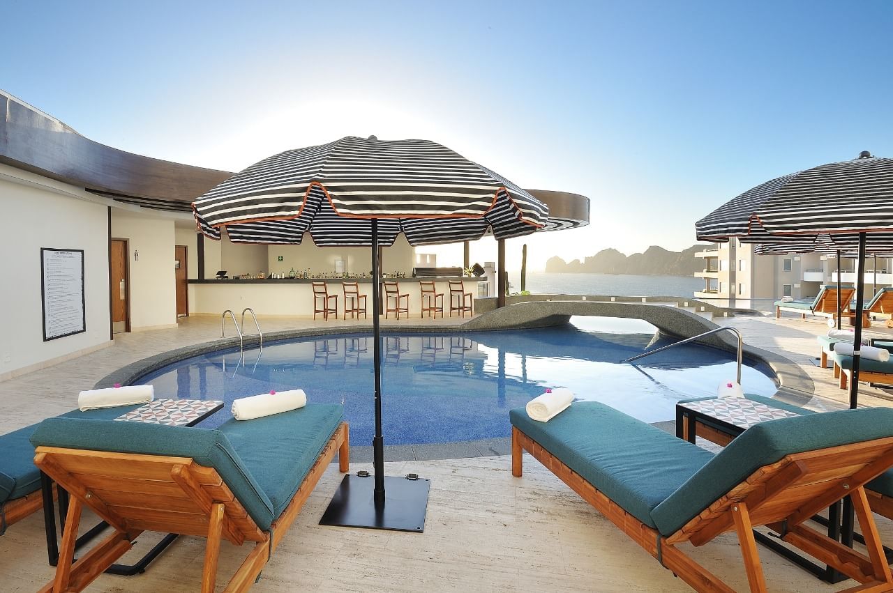 Sunbeds & parasols by the poolside at Cabo Villas Beach Resort