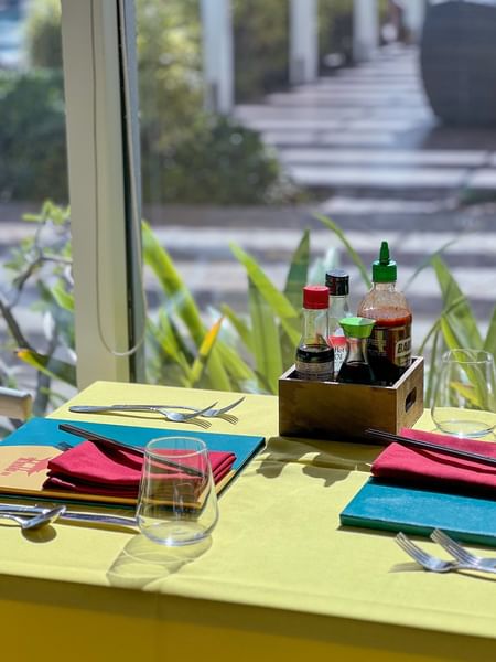Assorted hot sauce bottles by wooden box by a table in Tings on a Stick at Warwick Paradise Island Bahamas