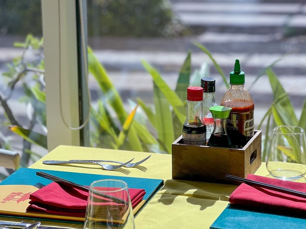 Assorted hot sauce bottles by wooden box by a table in Tings on a Stick at Warwick Paradise Island Bahamas