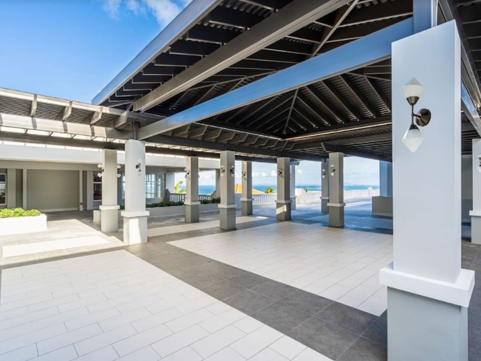 Mirador Terrace with a sleek design, featuring pillars, a tiled floor, and an ocean view at El Conquistador Resort