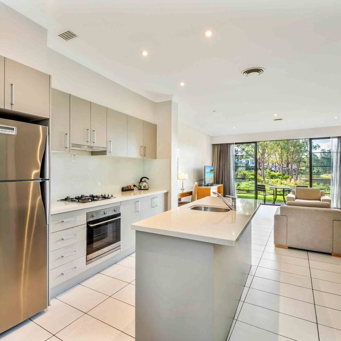 Two Bedroom Apartment kitchen with appliances opening to a bright living area at Mercure Kooindah Waters