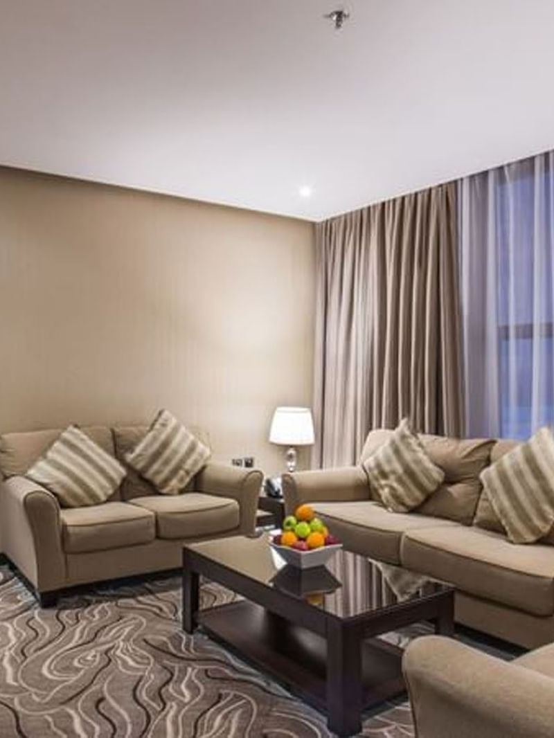 Illuminated Naviti by Warwick Al Khobar Hotel signage by glass windows under a clear twilight