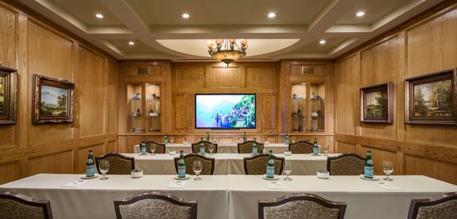 Classroom tables by wood paneling under a TV screen in the Coolidge Room at Mountain View Grand Resort & Spa