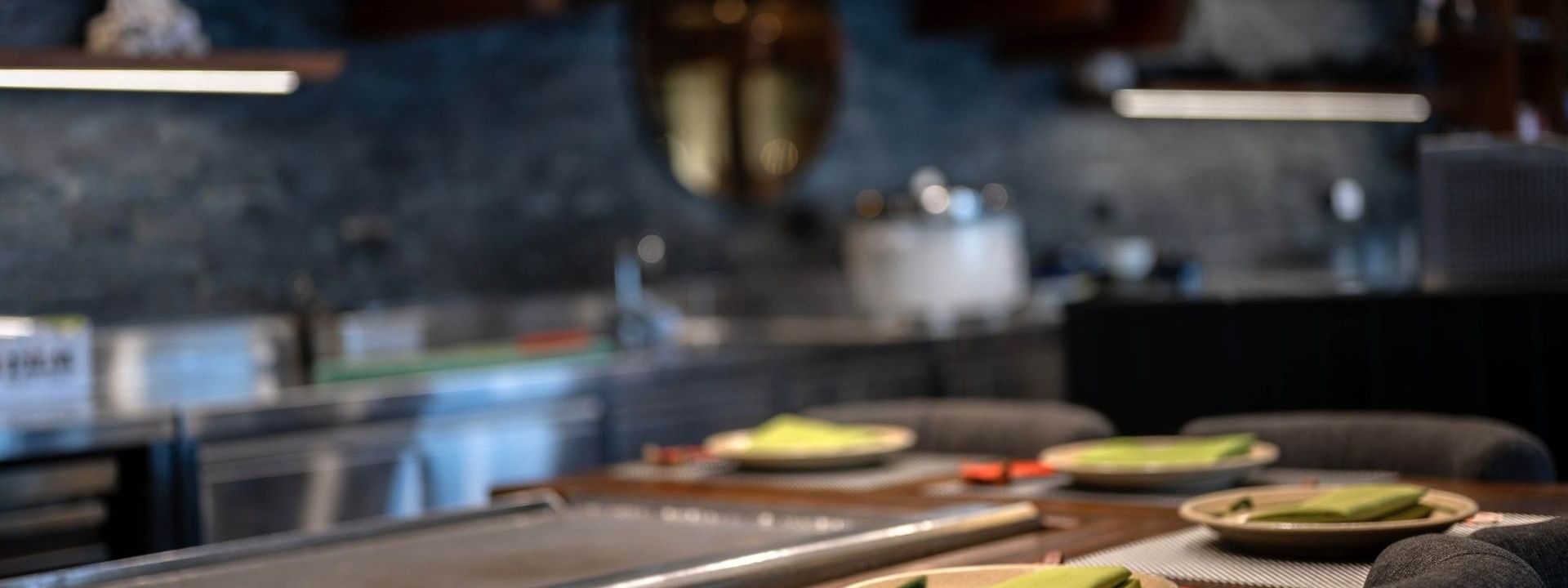 Plates with green napkins by a counter under a traditional wooden roof in Sazanami at Warwick Fiji Resort and Spa