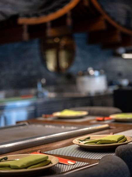 Plates with green napkins by a counter under a traditional wooden roof in Sazanami at Warwick Fiji Resort and Spa