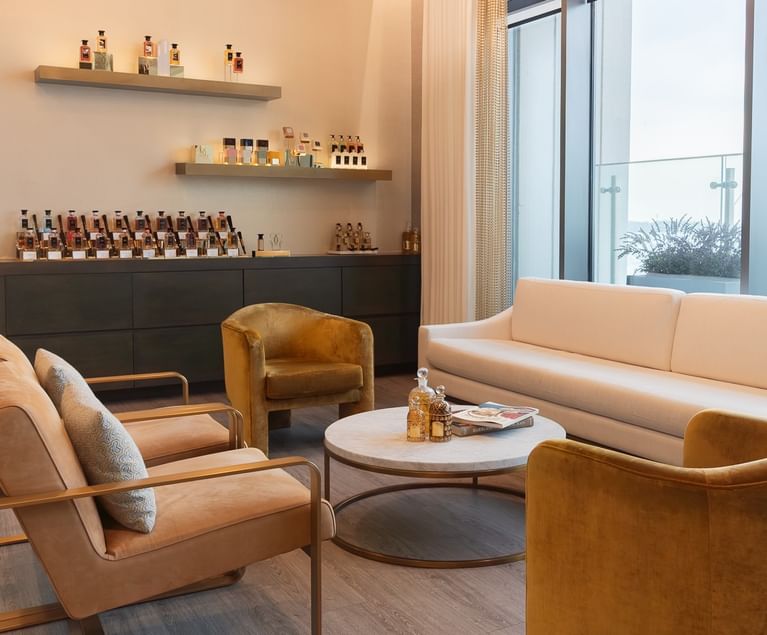 Guerlain Spa lounge with plush seating and elegant fragrance displays beside floor-to-ceiling windows at Hotel X Toronto