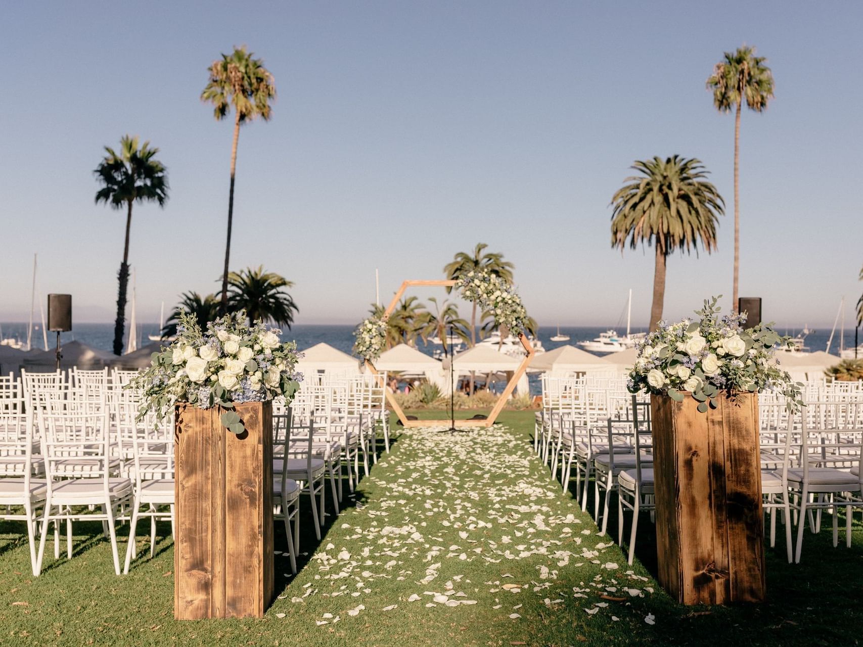 Decorated wedding event arranged with white chairs outdoors in Descanso Beach Club near Hotel Atwater