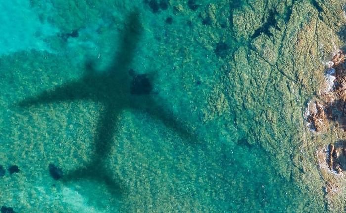 Aerial view of an airplane shadow over the sea near Falkensteiner Hotels & Residences