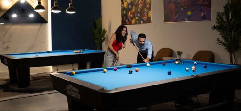 Couple enjoying billiards game together in the stylish lounge in Level Up - Indoor Gaming Hub at DAMAC Maison Aykon City