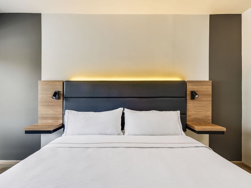 King-sized bed with a black head rest in Executive King Room at Fiesta Inn