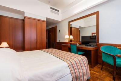 Comfy bed, cupboard & Large mirror with a TV in Business Room at Hotel Crivi's in Milan