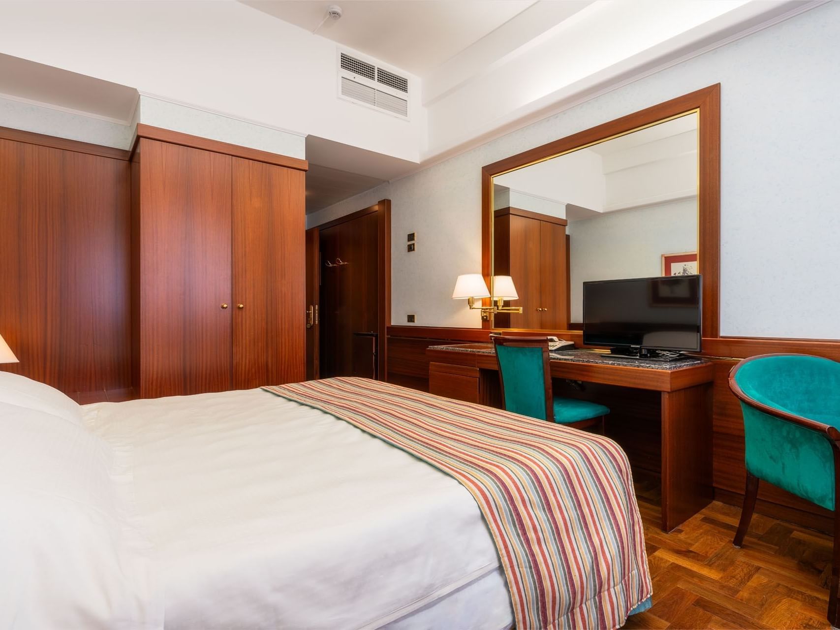 Comfy bed, cupboard & Large mirror with a TV in Deluxe Room at Hotel Crivi's in Milan