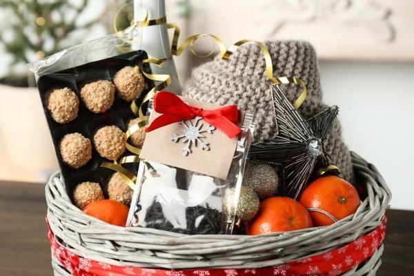 Christmas hamper with festive things inside including a drink, chocolates and fruit