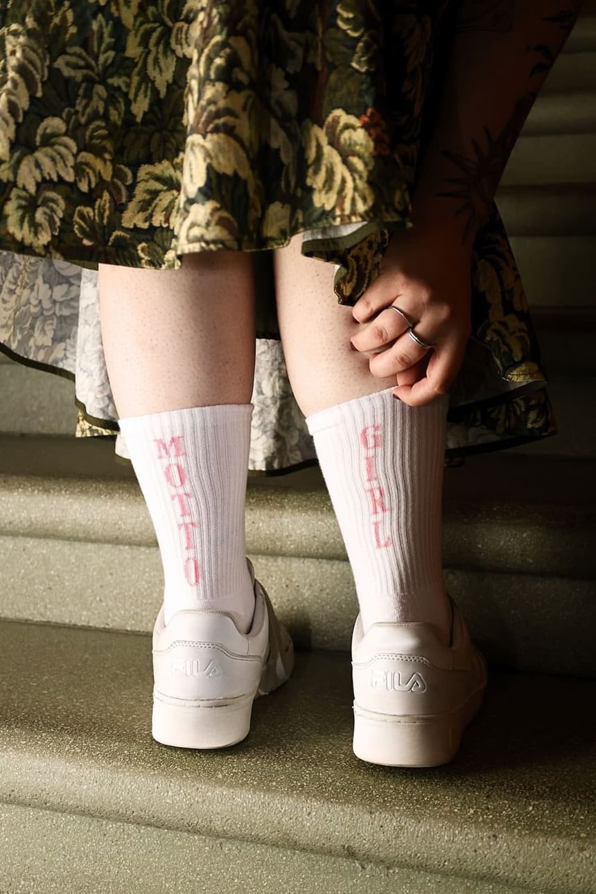 Weiße Socken mit der Aufschrift Motto Girl vom Hotel Motto Merch