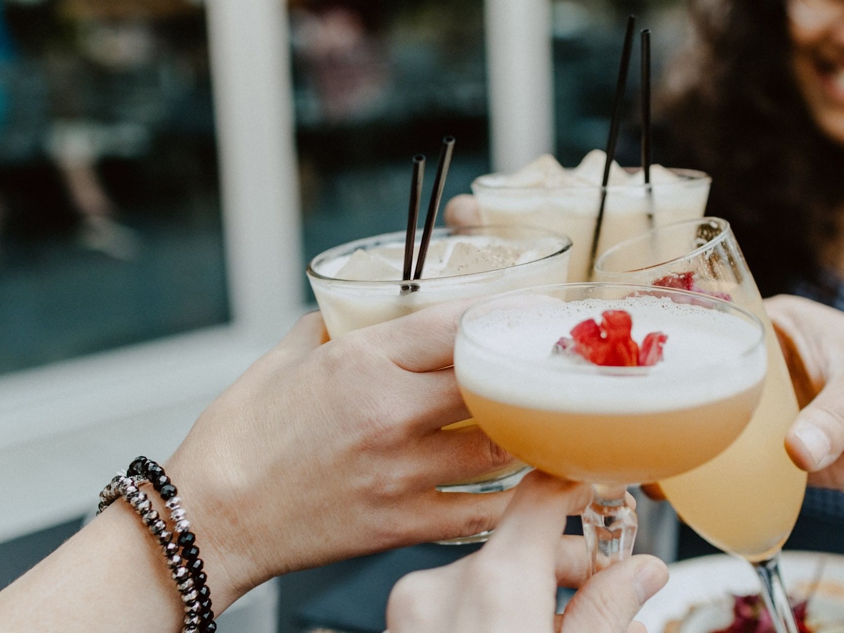 Four people toasting with cocktails at La Galerie Hotel