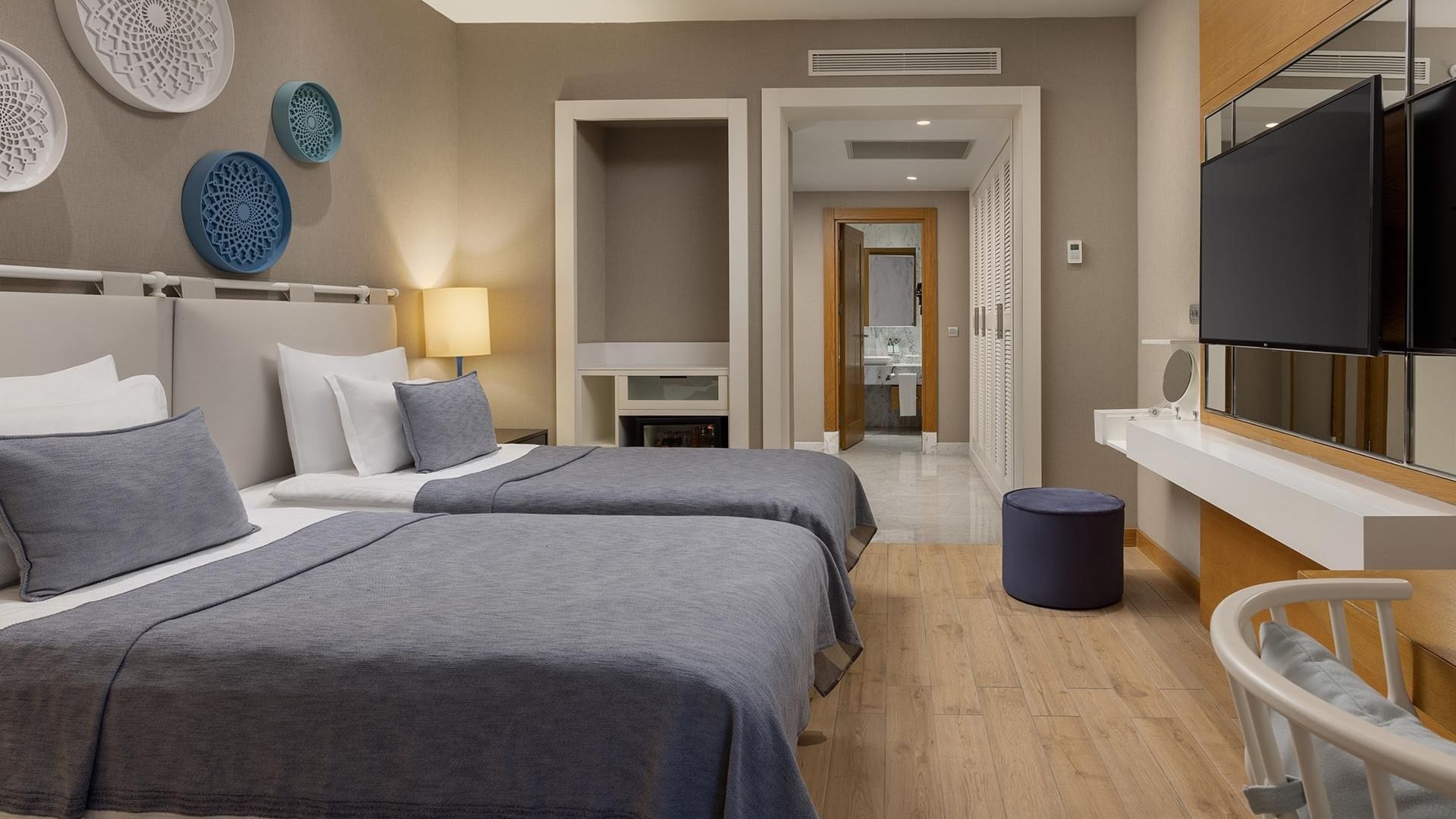 Titanic Luxury Bodrum’da iki yataklı, TV’li ve sandalyeli Exclusive Villa yatak odası.