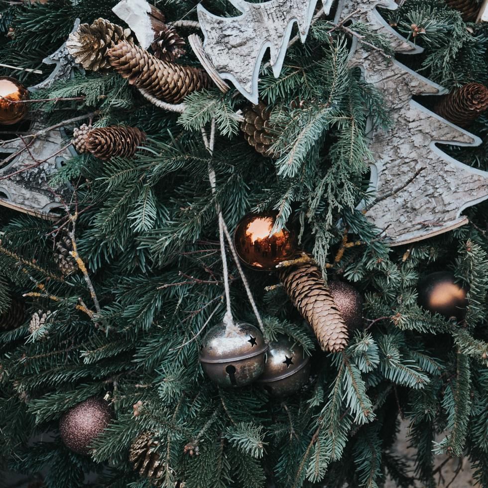 Fir branches with pine cones and golden ornaments amidst Christmas decorations at Falkensteiner Hotel Cristallo