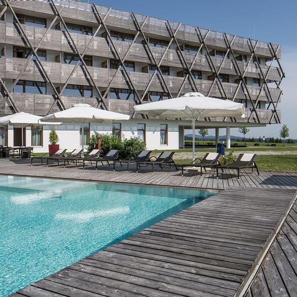 Sunbeds by the outdoor pool area at Falkensteiner Hotels