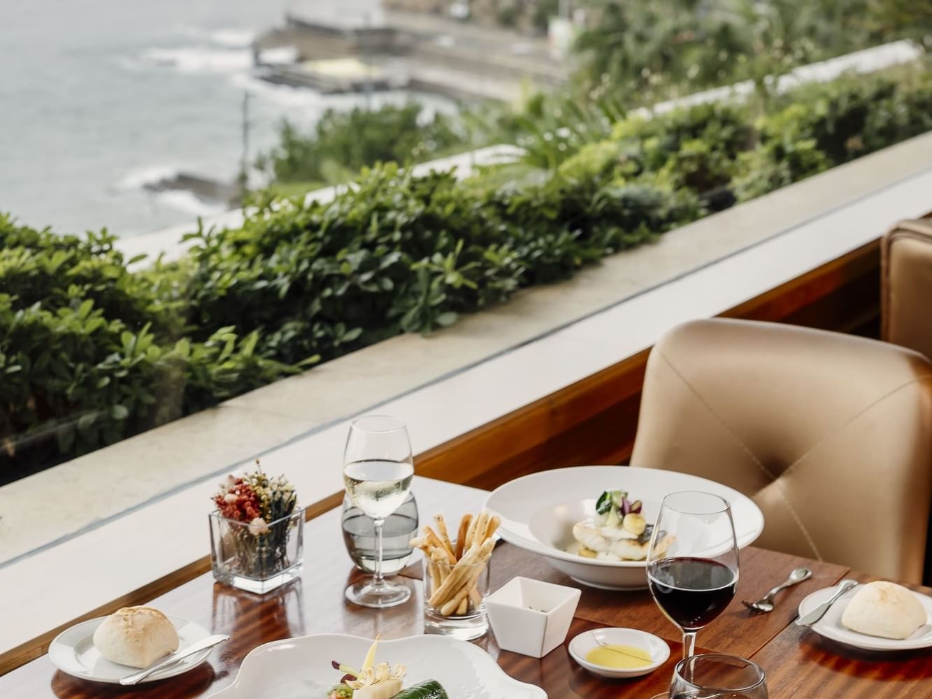 Table with gourmet meal and ocean view at Miragem Restaurant in Cascais.