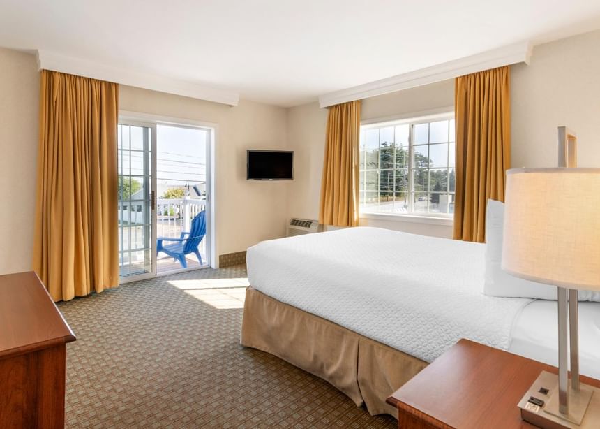 Single bed with a TV and a wooden desk at Ogunquit Collection