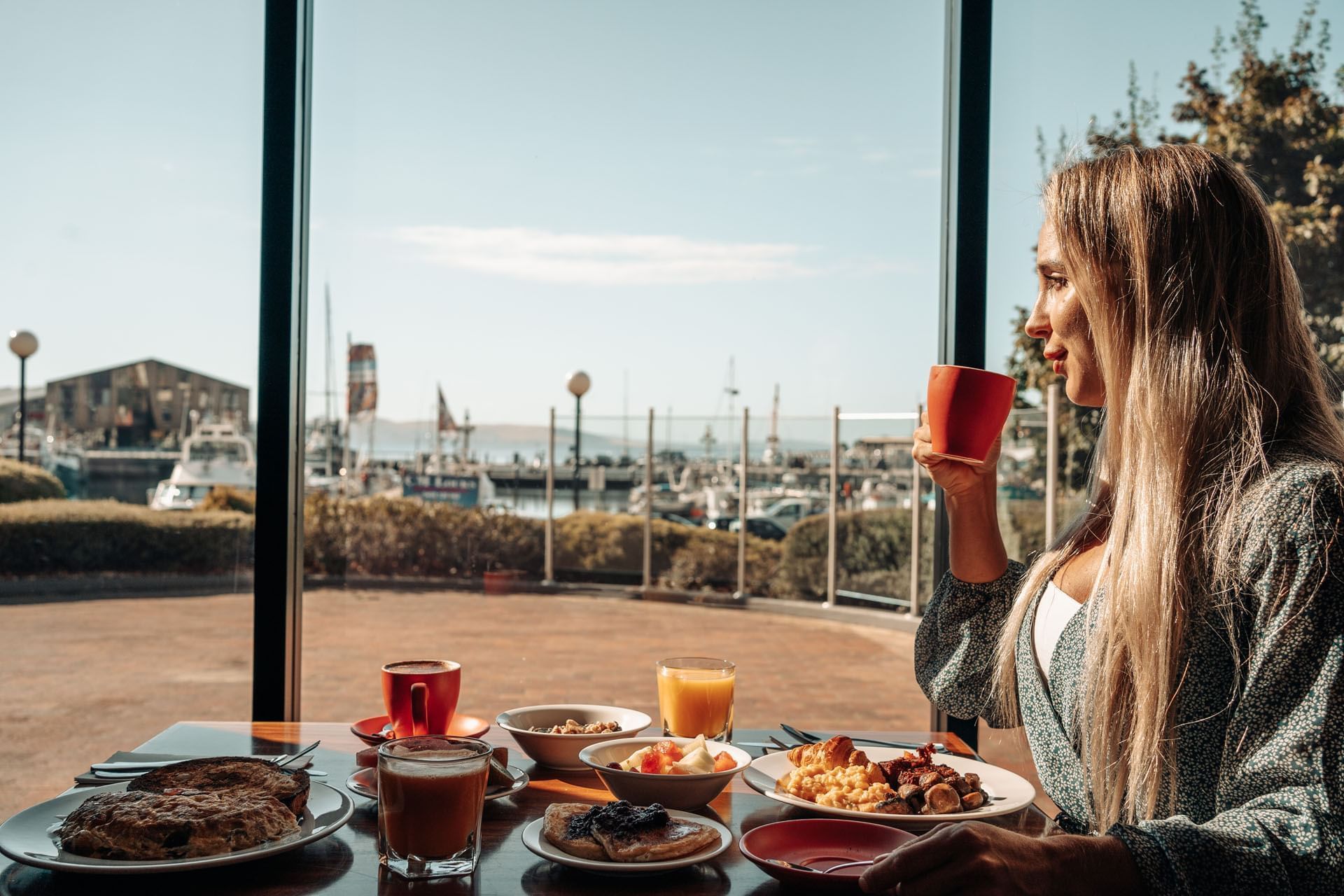 Guest enjoying breakfast with a view of the dock at Hotel Grand Chancellor Hobart