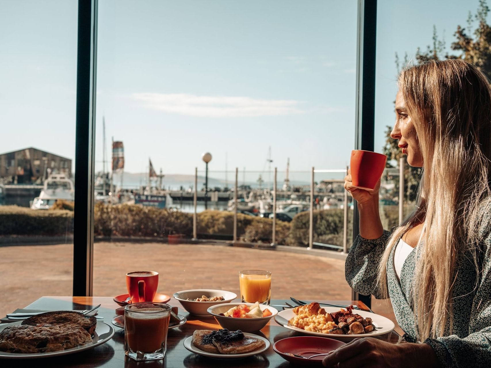 Guest enjoying breakfast with a view of the dock at Hotel Grand Chancellor Hobart