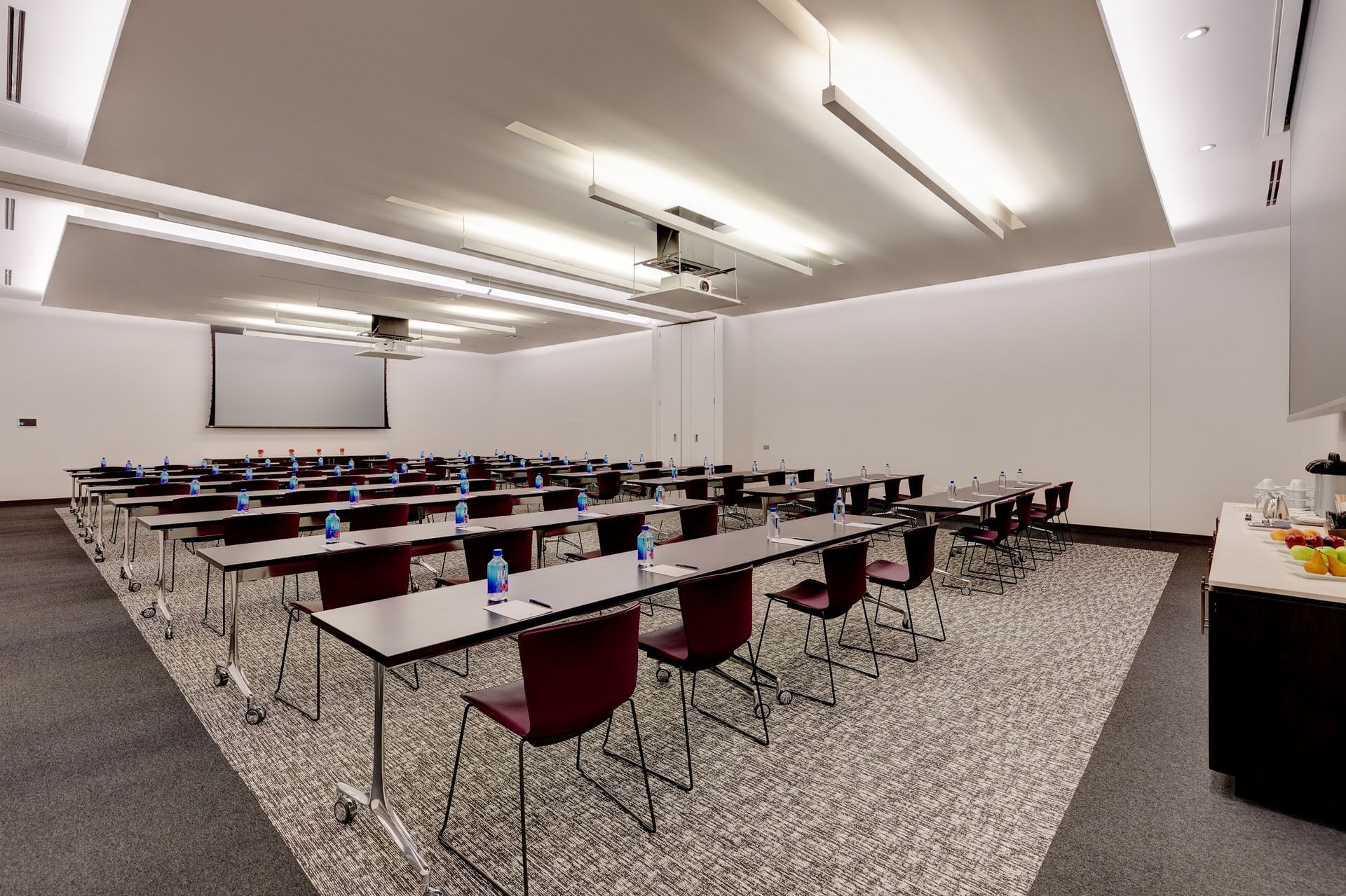 Classroom set-up in Humber Park with long tables and chairs facing presentation screen and projectororonto