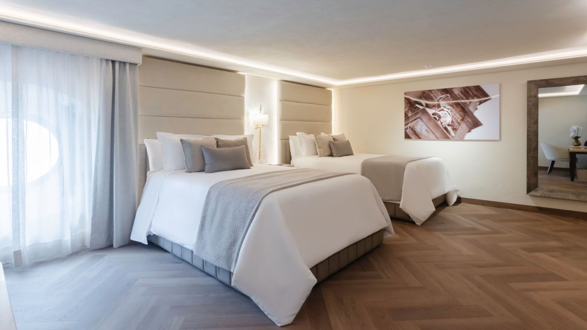 Two Double Deluxe with two beds, wooden floors, and a large framed artwork on the wall at Quinta Real Puebla